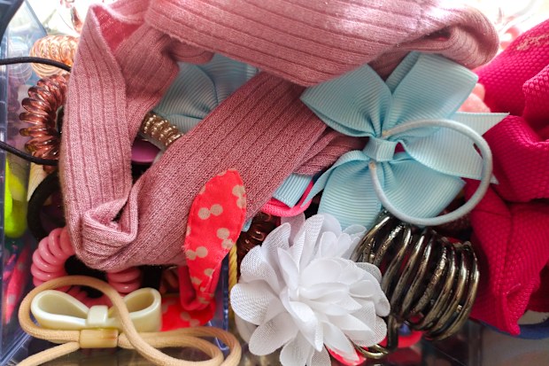 Overflowing container of colorful hair accessories. Concept childhood, organization, fashion. Use blog, webpage, print, social media posts.