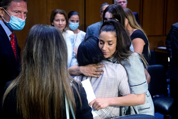 US Olympic gymnast Aly Raisman (center R) embraces Simone Biles after testifying during a Senate Judiciary hearing. 