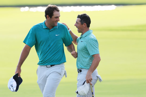 Scottie Scheffler of the United States congratulates Rory McIlroy of Northern Ireland on the 18th green after McIlroy won the Tour Championship at East Lake Golf Club.