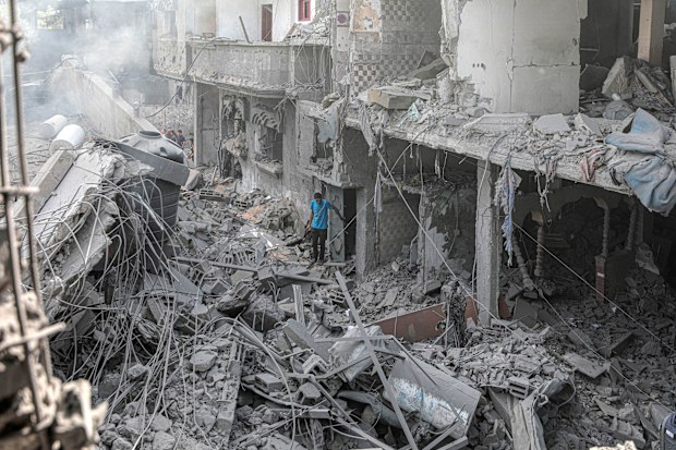 A man stands among the rubble of buildings destroyed in an Israeli bombing in central Gaza.