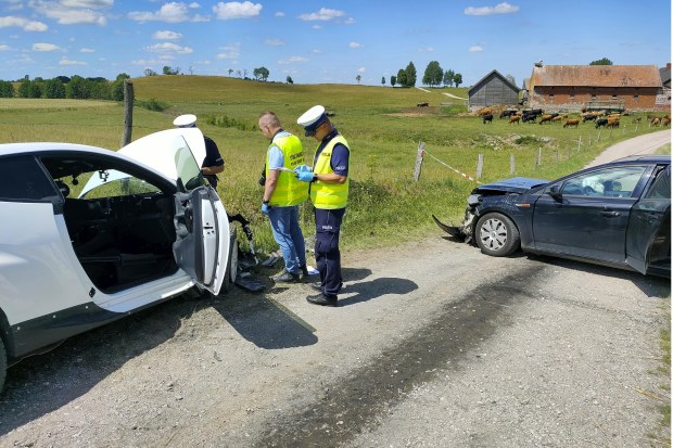 Police officers investigating the site of a crash between the white Toyota of eight-time world rally champion Sebastien Ogier and co-driver Vincent Landais and a local residents' Ford that collided head-on on a local road near the village of Wlosty.