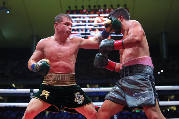 Canelo Alvarez of Mexico punches John Ryder of Great Britain.