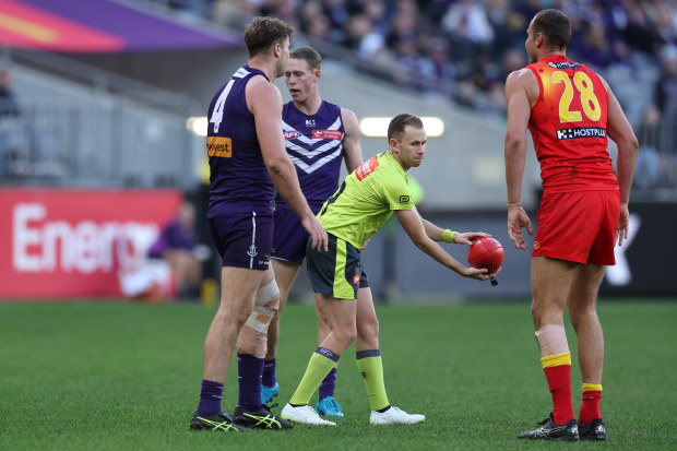 AFL Field Umpire, Alex Whetton throws the ball up during round 15.