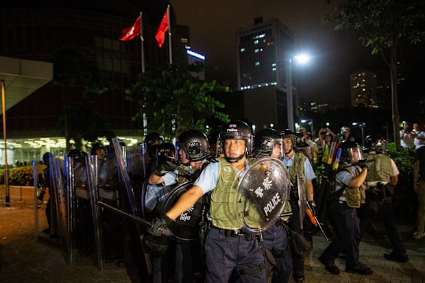 Riot police officers seen trying to removing protesters near the legislative council building.