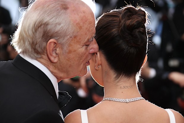 Bill Murray whispers into Selena Gomez's ear.