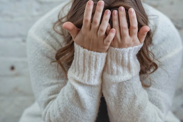 Woman with her head in her hands stock photo.