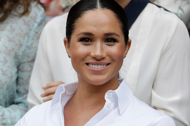 FILE - In this July 13, 2019 file photo Meghan, Duchess of Sussex smiles while sitting in the Royal Box on Centre Court to watch the women's singles final match between Serena Williams, of the United States, and Romania's Simona Halep on at the Wimbledon Tennis Championships in London. A British judge ruled Thursday Feb. 11, 2021, that a newspaper invaded Duchess of Sussex's privacy by publishing personal letter to her estranged father. (AP Photo/Ben Curtis, File)