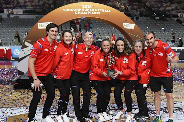 BRISBANE, AUSTRALIA - AUGUST 28: NSW Swifts head coach Briony Akle (centre) and the rest of the Swifts staff pose with the trophy after their victory with the during the 2021 Super Netball Grand Final match between Sydney Swifts and GWS Giants at Nissan Arena, on August 28, 2021, in Brisbane, Australia. (Photo by Albert Perez/Getty Images)