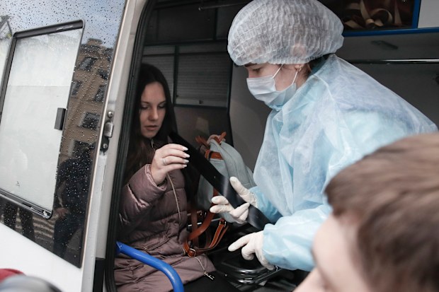 An emergency medic helps Alla Ilyina to fasten a seat belt inside an ambulance after a court session in St Petersburg.