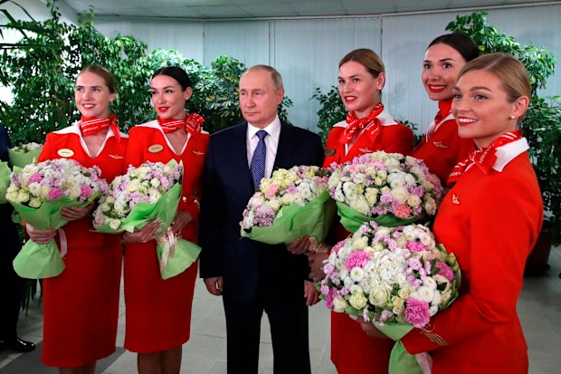 Russian President Vladimir Putin poses for a photo during his meeting with representatives of the flight crew of Russian airlines as he visits to Aeroflot Aviation School outside Moscow, Russia, Saturday, March 5, 2022 