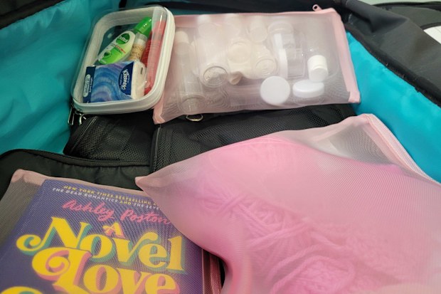 Suitcase packed with Kmart mesh pouches and clear case organiser