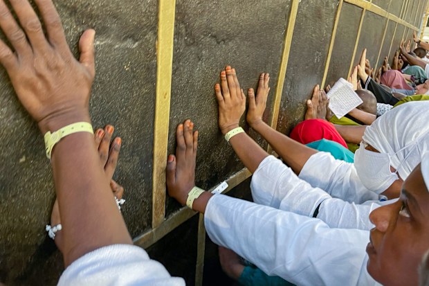 Muslim pilgrims pray in front of the Kaaba
