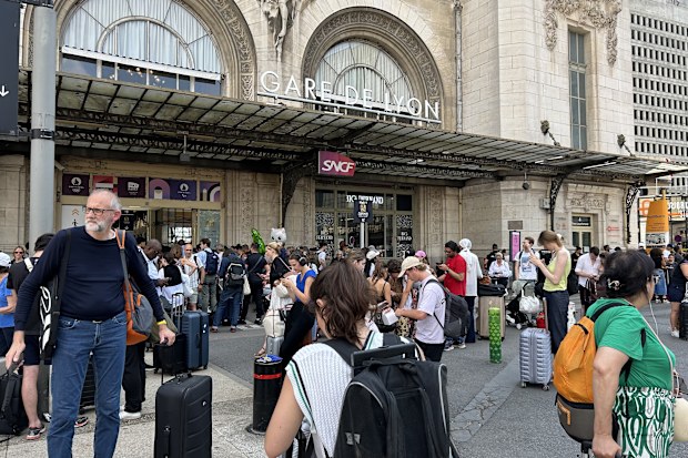 Stranded train passengers wait out delays outside Gare de Lyon in Paris on Wednesday July 31, 2024.