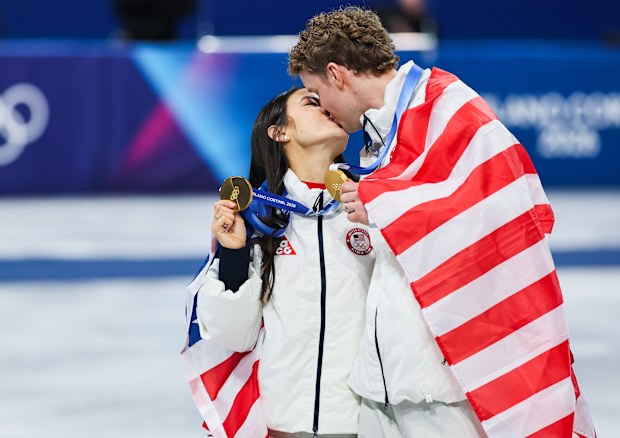 Winter Olympics Gold medalists Madison Chock and Evan Bates share a kiss after the medal ceremony at the Milano Cortina 2026 Winter Olympic games on February 8, 2026.