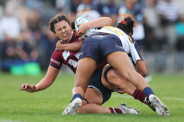 Annabelle Codey of the Reds is tackled by Faitala Moleka of the Brumbies.