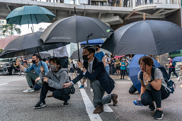 November 13: Pro-democracy protesters hold umbrellas as they walk on a street during a standoff with police.