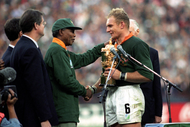 South Africa captain Francois Pienaar receives the William Webb Ellis Trophy from Nelson Mandela.