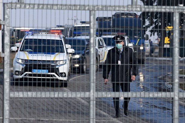 A motorcade with police cars and busses with passengers from the Ukrainian aircraft chartered by the Ukrainian government for evacuation from the Chinese city of Wuhan, leave the the gate upon their landing at airport outside Kharkiv.
