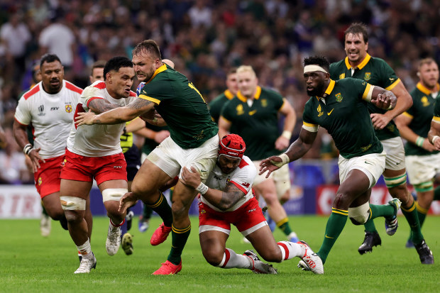 Andre Esterhuizen of South Africa is tackled by Sione Talitui and Pita Ahki of Tonga.
