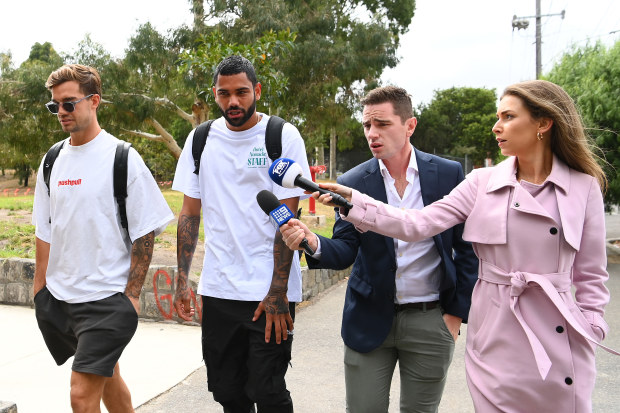 MELBOURNE, AUSTRALIA - FEBRUARY 27: Jy Simpkin and Tarryn Thomas of the Kangaroos are flanked by reporters as they arrive at the football club during a North Melbourne Kangaroos AFL media opportunity at Arden Street Ground on February 27, 2023 in Melbourne, Australia. (Photo by Quinn Rooney/Getty Images)
