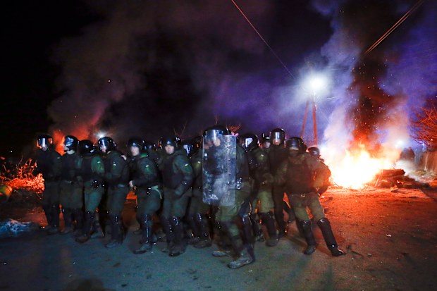 Ukrainian riot police prepare to push protesters, who planned to stop buses carrying passengers evacuated from the Chinese city of Wuhan, outside Novi Sarzhany, Ukraine.