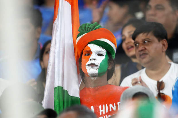 An Indian fan watches on.