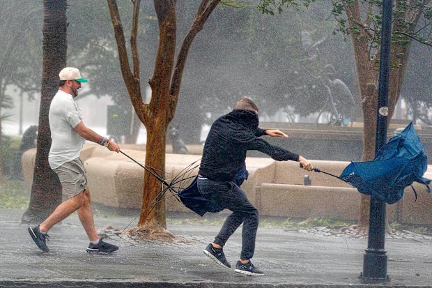 Wind gusts, blowing down King Street, twist umbrellas during Hurricane Ian in Charleston, South Carolina, on Friday, September 30, 2022 