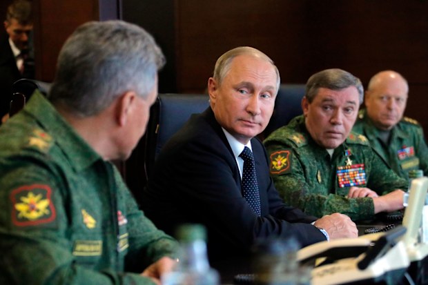 Russian President Vladimir Putin confers with his top military advisors.