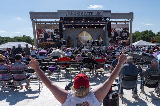 A person worships as a recorded video message from President Donald Trump plays at Rededicate 250, a mostly conservative Christian prayer gathering in honor of the United States' 250th anniversary, on the National Mall, Sunday, May 17, 2026, in Washington. (AP Photo/Julia Demaree Nikhinson)