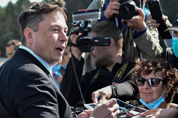 Technology entrepreneur Elon Musk gives autographs as he visits the Tesla Gigafactory construction site in Gruenheide near Berlin
