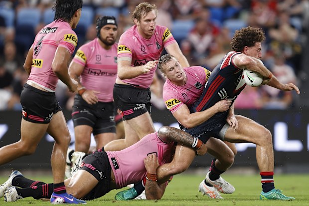 Los jugadores de los Panthers se acercan a Mark Nawaqanitawase de los Roosters.