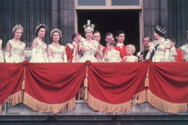 2nd June 1953:  The newly crowned Queen Elizabeth II waves to the crowd from the balcony at Buckingham Palace. Her children Prince Charles and Princess Anne stand with her.  (Photo by Hulton Archive/Getty Images)