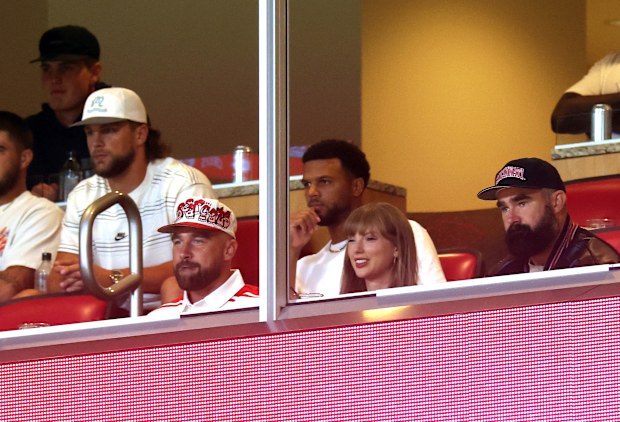 KANSAS CITY, MISSOURI - AUGUST 28:  Travis Kelce #87 of the Kansas City Chiefs, Taylor Swift and Jason Kelce watch during the first half of the game between the Cincinnati Bearcats and the Nebraska Cornhuskers at Arrowhead Stadium on August 28, 2025 in Kansas City, Missouri. (Photo by Jamie Squire/Getty Images)