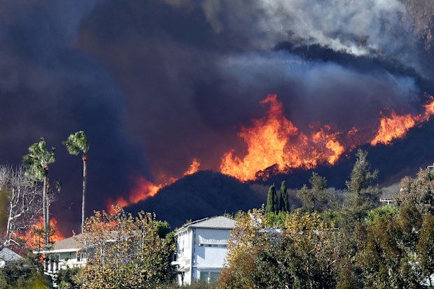 PACIFIC PALISADES, CALIFORNIA - JANUARY 07: The Palisades Fire burns near homes amid a powerful windstorm on January 7, 2025 in Pacific Palisades, California. The fast-moving wildfire is threatening homes in the coastal neighborhood amid intense Santa Ana Winds and dry conditions in Southern California. (Photo by Mario Tama/Getty Images)