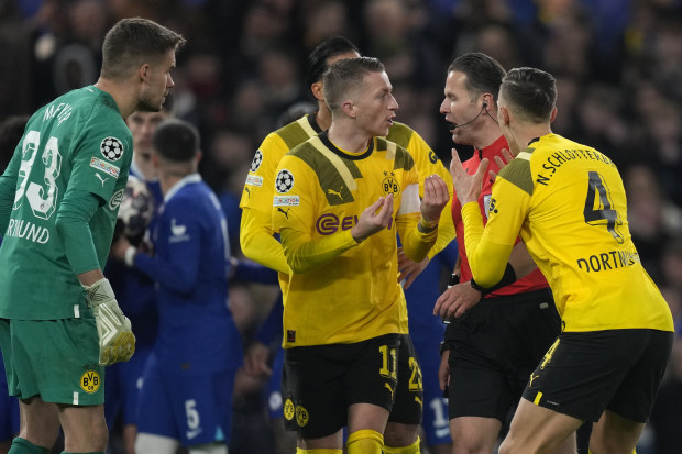 Players of Dortmund argue with referee Danny Makkelie after ruling the penalty kick be retaken.