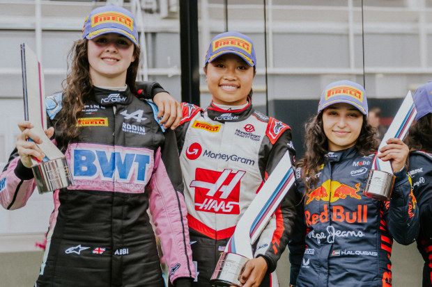 Race winner Chloe Chambers of United States and Campos Racing (middle) with second placed Abbi Pulling (left) and third placed Hamda Al Qubaisi (right) celebrate in the paddock during the F1 Academy round in Spain.