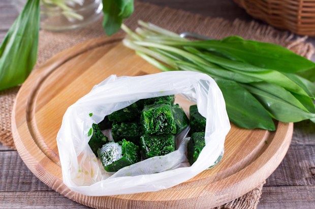 Frozen greens cubes on a wooden cutting board on a table