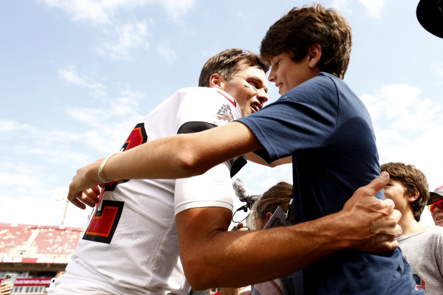 Tom Brady hugs his son John Edward Thomas Moynahan on the sidelines prior to the game against the Green Bay Packers at Raymond James Stadium on September 25, 2022 in Tampa, Florida. 