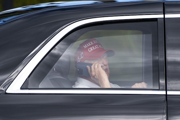 President Donald Trump talks on the phone as he arrives at the Trump International Golf Club on April 4, in West Palm Beach, Florida.
