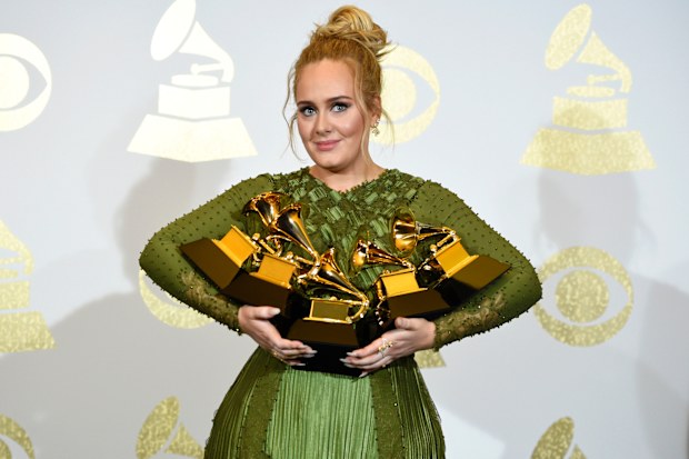 Adele poses in the press room with the awards for album of the year for "25," song of the year for "Hello," record of the year for "Hello," best pop solo performance for "Hello," and best pop vocal album for "25" at the 59th annual Grammy Awards on Feb. 12, 2017, in Los Angeles. 
