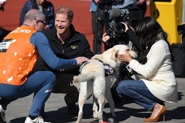 Prince Harry, Duke of Sussex and Meghan, Duchess of Sussex interact with members of Team Netherlands during the Athletics on day two of the Invictus Games The Hague 2020 at Zuiderpark on April 17, 2022 in The Hague, Netherlands. (Photo by Lukas Schulze/Getty Images for Invictus Games The Hague 2020)