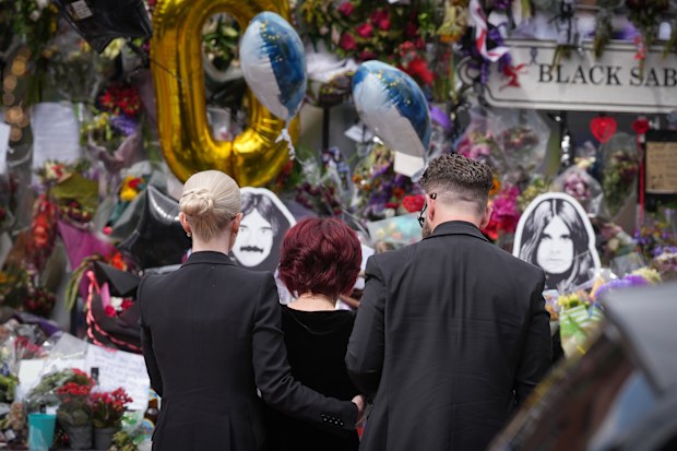 BIRMINGHAM, ENGLAND - JULY 30: Kelly Osbourne, Sharon Osbourne and Jack Osbourne stop to view tributes to the late Ozzy Osbourne from fans at Black Sabbath Bench and Bridge as his funeral cortege travels through his home city of Birmingham on July 30, 2025 in Birmingham, England. The Black Sabbath frontman passed away on July 22nd at the age of 76. His death occurred just a little over two weeks after his final live performance at the 'Back to the Beginning' concert in his hometown of Birmingham