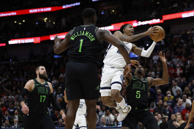 NEW ORLEANS, LOUISIANA - DECEMBER 19: Ja Morant #12 of the Memphis Grizzlies shoots the ball over Zion Williamson #1 of the New Orleans Pelicans at Smoothie King Center on December 19, 2023 in New Orleans, Louisiana. 