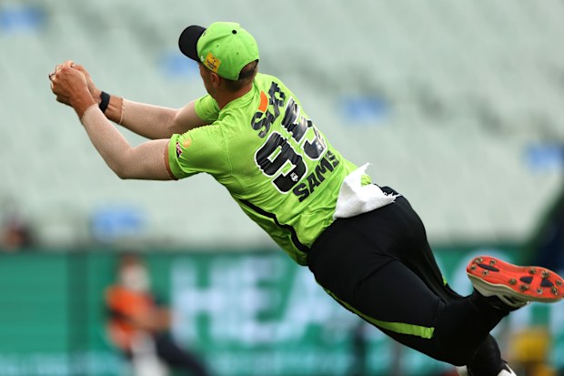 Daniel Sams of the Thunder takes a catch to dismiss Alex Carey of the Strikers.