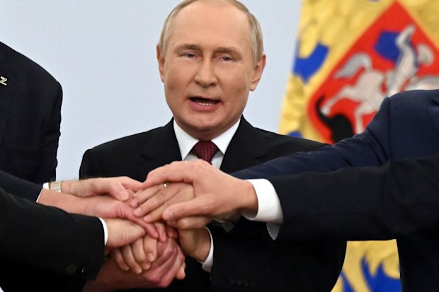 Russian President Vladimir Putin joins hands with Moscow-appointed head of Kherson Region Vladimir Saldo, Moscow-appointed head of Zaporizhzhia region Yevgeny Balitsky, Denis Pushilin, leader of self-proclaimed Donetsk People's Republic and Leonid Pasechnik, leader of self-proclaimed Luhansk People's Republic, as they celebrate at the Kremlin during a ceremony to sign the treaties for four regions of Ukraine to join Russia, in Moscow, Friday, Sept. 30, 2022. 