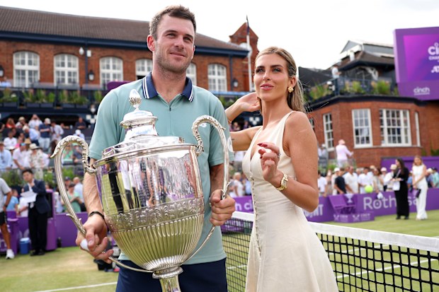 Tommy Paul and Paige Lorenze pose with the cinch Championships 2024 winners trophy following victory against Lorenzo Musetti of Italy in the Men's Singles Final match of the cinch Championship at The Queen's Club on June 23, 2024 in London, England. 