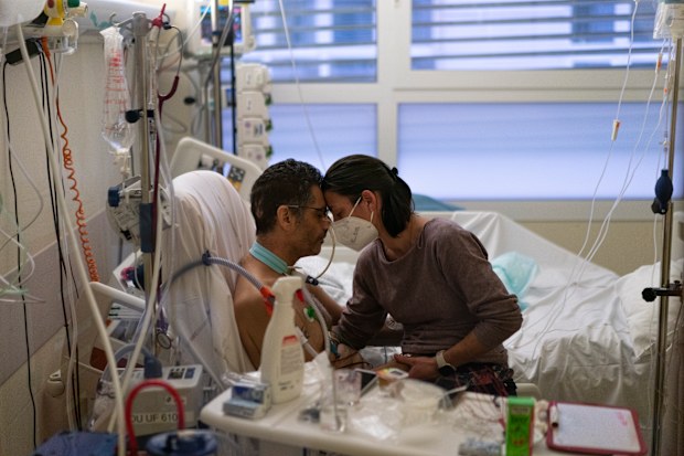 Amelie and Ludo Khayat hold each other during a visit at the COVID-19 intensive care unit of the la Timone hospital in Marseille, southern France, Thursday, Dec. 23, 2021.