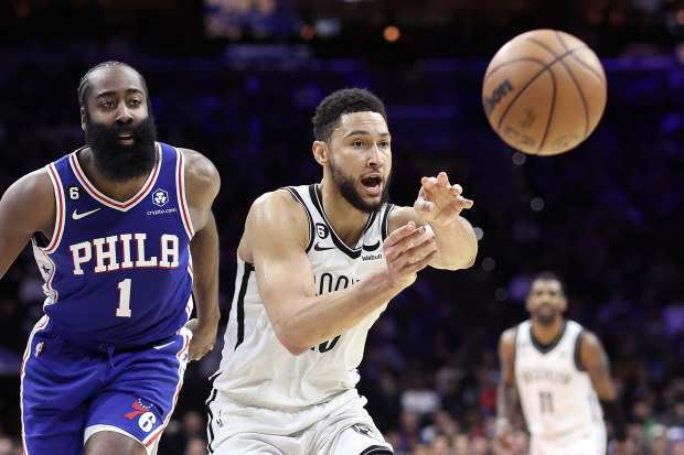 Ben Simmons of the Brooklyn Nets passes past James Harden.