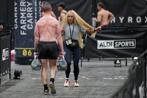 10 April 2025, North Rhine-Westphalia, Cologne: A participant carries weights during a HYDROX competition at the "Fibo 2025" fitness trade fair. HYROX is part of indoor fitness and combines eight kilometers of running with eight functional workout stations. The trade fair presents new trends in fitness, wellness and health to trade visitors and consumers. Photo: Henning Kaiser/dpa (Photo by Henning Kaiser/picture alliance via Getty Images)