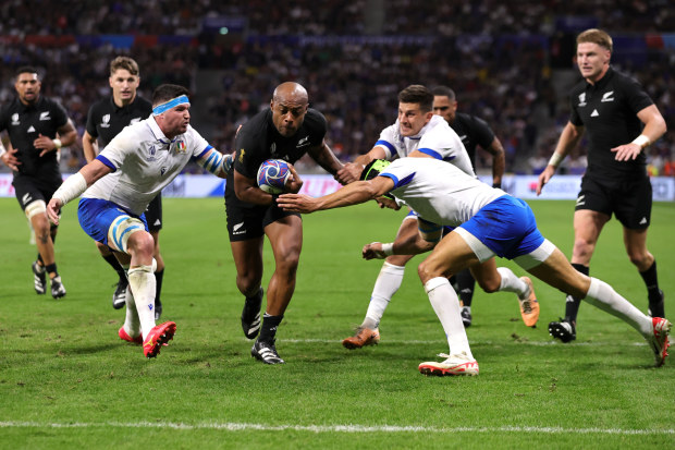 New Zealand's Mark Telea breaks through the Italian defence for his first try of the match.